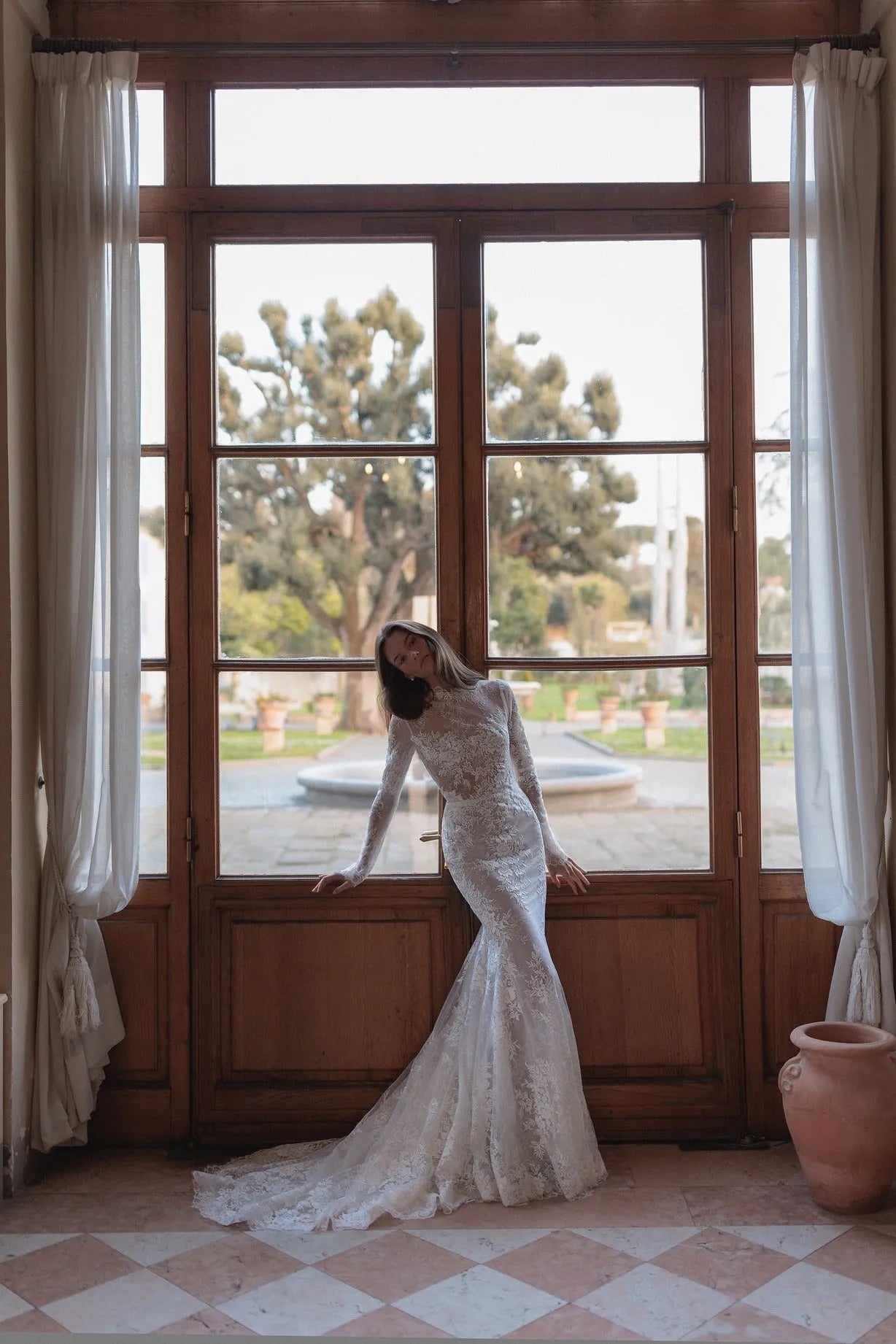Meticulously detailed embroidery over the translucent long sleeve top and smooth mermaid tail skirt.