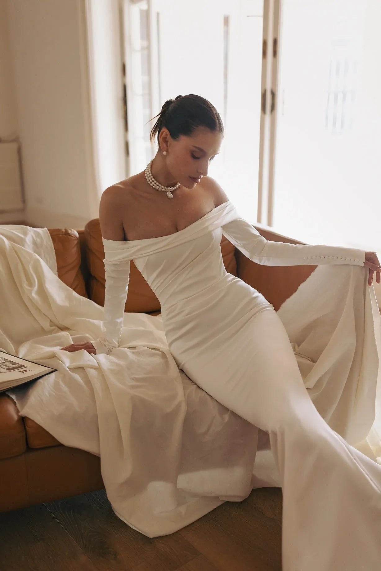 cold-shoulder long sleeve dress with slight side-wrapped silhouette and elongated trail.